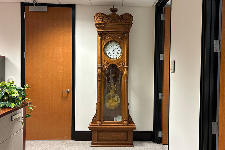 An oak floor clock with a carved crown top