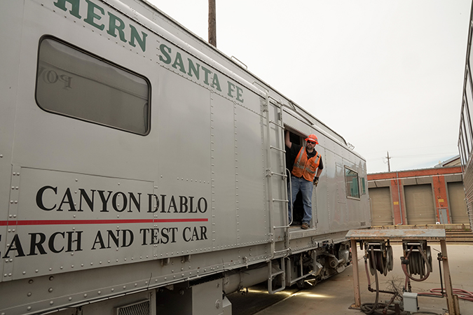 Senior Engineer I Darrell Krueger stands on one of the TR&D test cars that has the THOR system installed. THOR is mounted underneath the car and is the visual system mentioned in the article.